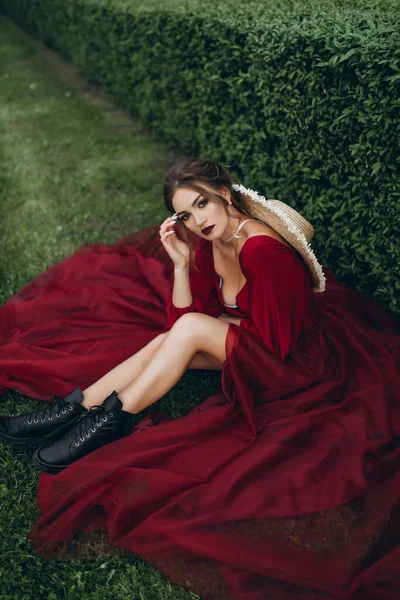 Chica Vestido Rojo Sombrero Mimbre Sienta Calle Cerca Los Arbustos — Foto de Stock