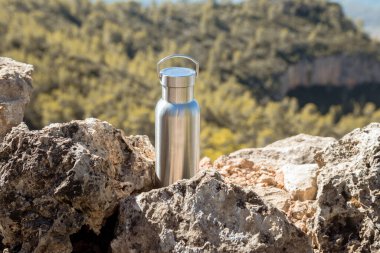 Yürüyüş yolunda su içmek için alüminyum bir termal şişe alıyorum.