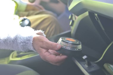 Araçta V-16 acil durum ışığı olan yelekli bir kadın var.