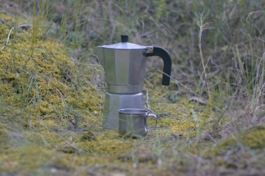 Alüminyum kahve makinesi, alüminyum bardakla ormanda kamp yapıyor.