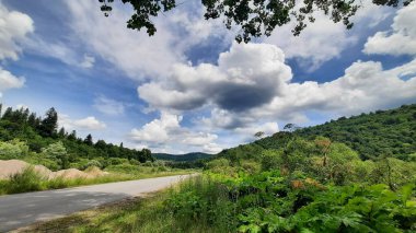 Dağlarda yol yeşil çimenler ve bulutlar