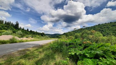 Dağlarda yol yeşil çimenler ve bulutlar