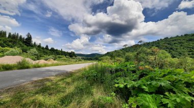 Dağlarda yol yeşil çimenler ve bulutlar