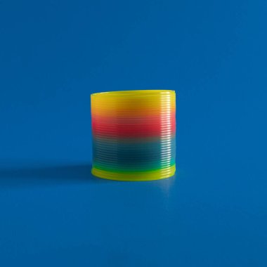 Retro Toy, Rainbow color elastic Spring and blue background.
