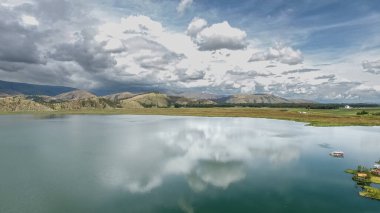 Huzur Yansıması: Dağlı Göl Manzarası ve Bulutlu Gökyüzü
