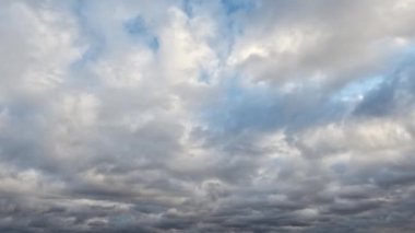 Kalın bulutlar mavi gökyüzünde süzülür.