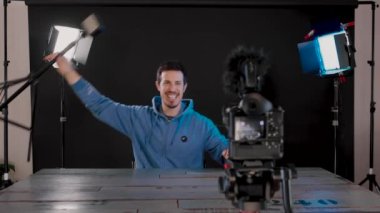 Işık tripod fonksiyonlarını gösterirken sosyal ağ için kamera ile video içeriği oluşturan genç ya da etkili. Yeni dijital iş akımları, teknoloji. Gerçek zamanlı 4k video.