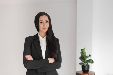 Uzun saçlı, gülümseyen beyaz bir kadının kurumsal portresi ofiste duruyor, kollarını kavuşturup kameraya bakıyor. Yönetici, iş kadını. Kapalı, Yatay, Boşluğu Kopyala