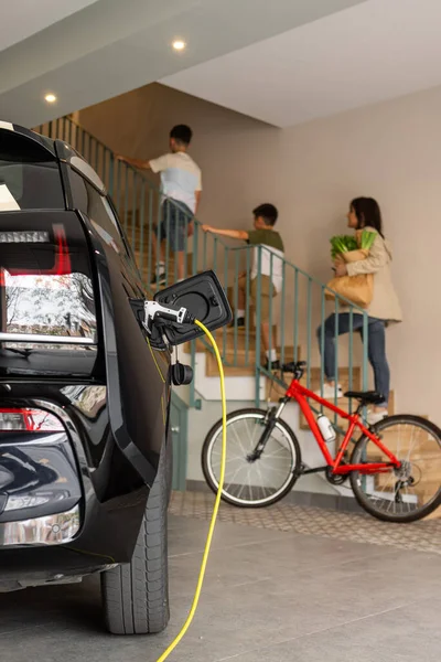 Woman Boys Climb Stairs Home Whilst Leaving Electric Vehicle Charge — Stock Photo, Image