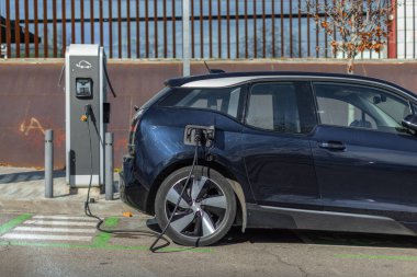 Halka açık bir şarj istasyonuna bağlı elektrikli bir araç, kentsel alanlarda sürdürülebilir ve temiz hareketliliği teşvik ediyor. Kopyalama uzayı, yatay