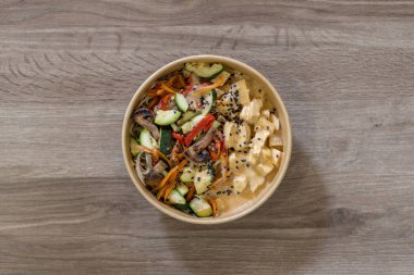 Tofulu, taze sebzeli ve siyah susam tohumlu kremalı lezzetli bir şehriye tabağı. Çevre dostu bir kasede servis edilmiş, restoran menüleri ve paket servis için ideal.. 