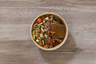 Erişte, taze sebze ve susam tohumlu Asya usulü lezzetli bir et yemeği, çevre dostu bir kasede servis edilir. Restoran menüleri ve paket servis sunumları için ideal.