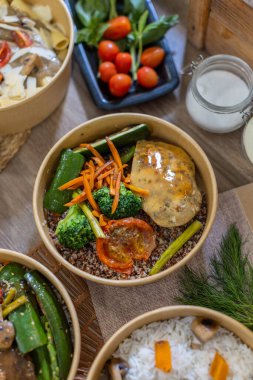 Izgara tavuk, sebze, kinoa, makarna ve pirinçle servis edilen çeşitli yemek kaselerinin genel manzarası. Taze bitkiler, domatesler ve cam kavanoz detay ekler. Renkli yemek tasarımı. Dikey, kopyala.