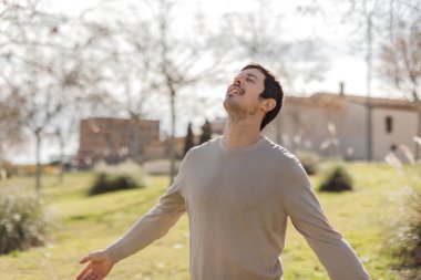 İnsan, gözleri kapalı, yumuşak kış güneşi altında nazikçe gülümseyen sessiz anlardan hoşlanır. Huzuru, yansımayı, zihinsel berraklığı gösteriyor. Sakinlik, sağlık ya da yaşam tarzı kavramları için idealdir. Yatay, bulanık park.