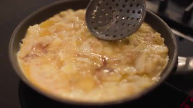 Patates ve yumurtadan yapılmamış İspanyol omletinin yüksek açılı detaylı çekimi. Akdeniz mutfağında ev yemeğinin ilk aşamalarını yakalıyor. Yatay, 4K