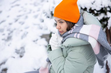 Young woman in warm clothes on a cold snowy day