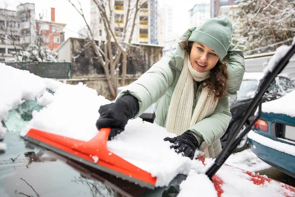 若いです女性クリーニング彼女の車から雪で背中 — ストック写真
