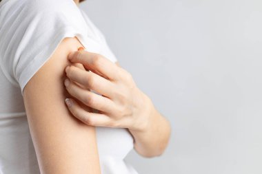 Young woman scratching her itchy arm. Skin problems concept