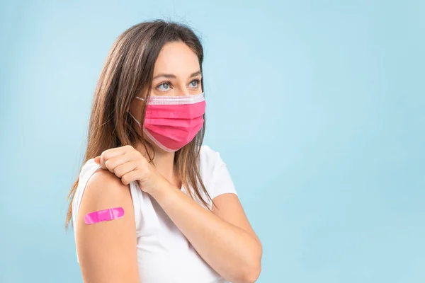 Young woman with protective mask after vaccination against coronavirus. Virus protection. COVID-2019.