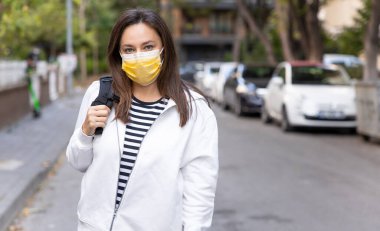 Coronaviru 'yu engellemek için yüz koruyucu maske takan genç bir kadının portresi.