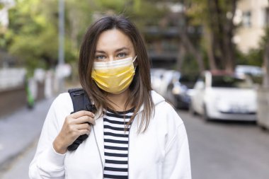 Coronaviru 'yu engellemek için yüz koruyucu maske takan genç bir kadının portresi.