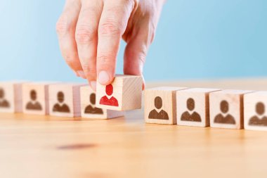 Kalabalıktan farklı elle seçilmiş ahşap küpteki kişi simgesi
