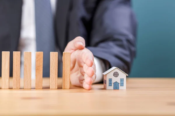 Female Hand Stops Wooden Dominoes Falling Model House — Stock Photo, Image