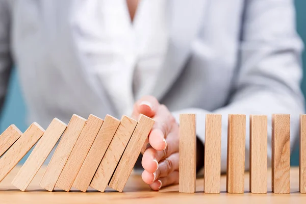 Woman Hand Stopping Falling Wooden Dominoes Effect Wooden Table — Stock Photo, Image