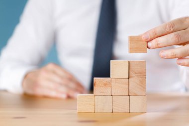 İş adamı odun yığını düzenliyor. Büyüme süreci için iş konsepti