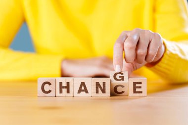 Woman hand flip wooden cube with word change to chance letters