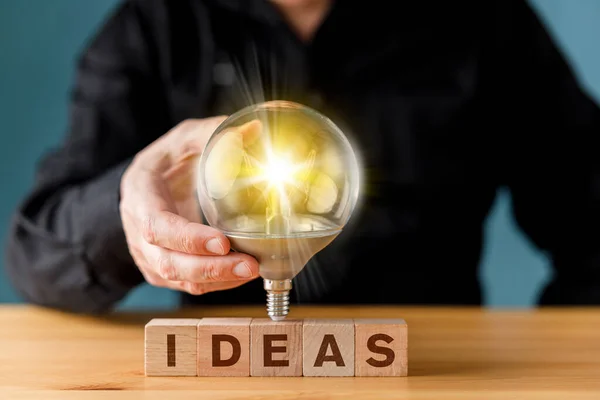 Man Holding Glowing Light Bulb Ideas Wording Wooden Block Creative — Stock Photo, Image