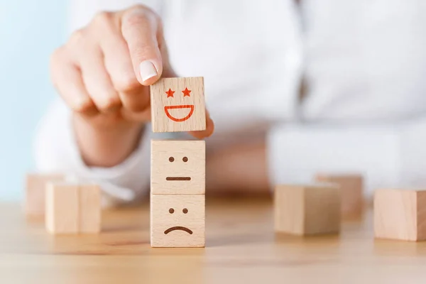 お客様の手は 木製のキューブ上の笑顔の顔を選択 サービス評価 満足コンセプト — ストック写真