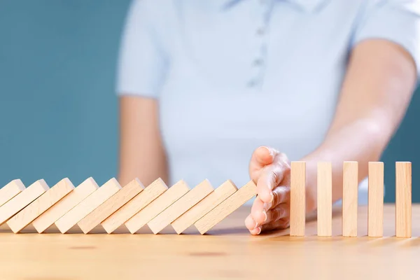 Frauenhand Stoppt Fallende Holz Dominosteine Auf Holztisch — Stockfoto