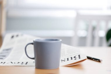 Evdeki masada bir fincan kahve ve gazete.