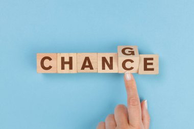 Woman hand flip wooden cube with word change to chance letters