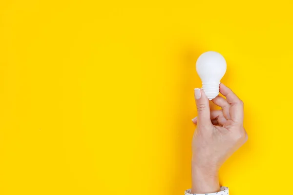 Woman Hand Holding White Light Bulb Yellow Background — Stock Photo, Image