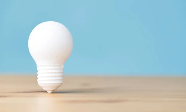 Light Bulb Pastel Blue Background Wooden Table — Stock Photo, Image