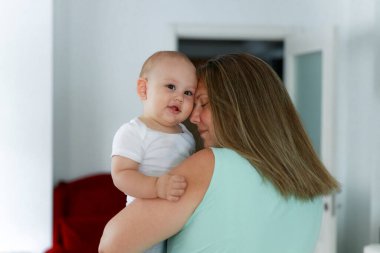 Mutlu bir anne, kucağında küçük bir bebekle.