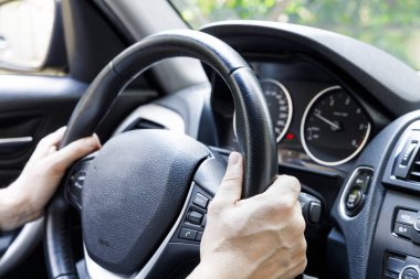 Male driver hand holding on steering wheel. Urban driving lifestyle  clipart