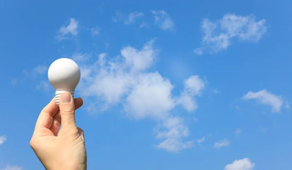 青いリスクに対して白い電球を保持する女性の手 — ストック写真