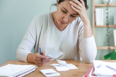 Depresyonda olan genç bir kadın fatura tutuyor, ofisteki işten çıkarılmayla ilgili sorunları var. Yurtiçi faturalar için pahalı harcamalar. Maddi sorunları olan bir kadın..
