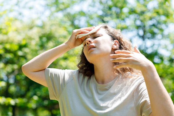 Young woman having hot flash and sweating in a warm summer da