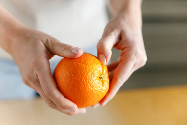 stock image Woman's hand peeling an orang