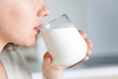 Genç kadın süt içiyor 