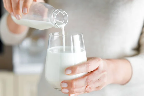 若い女性はガラス瓶から毎日ミルクを注いでいます — ストック写真