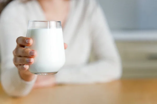 若い女性は台所でミルクのガラスを保持します — ストック写真