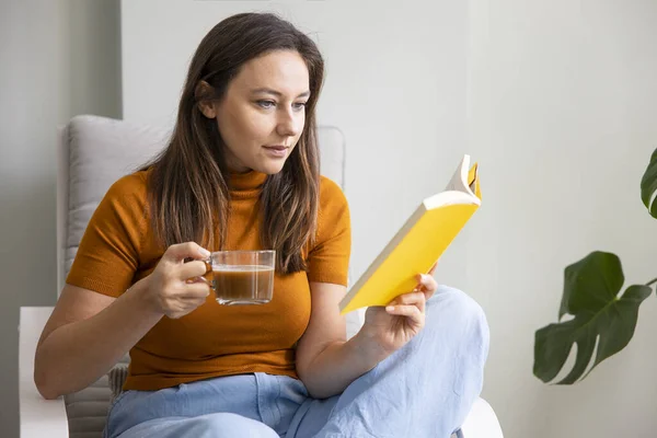 Jonge Vrouw Drinken Haar Koffie Het Lezen Van Een Boek — Stockfoto