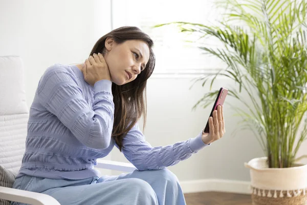 Young woman suffering having poor posture using mobile phone