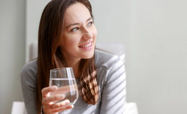 Mujer Joven Bebiendo Agua Sentada Sofá Casa Beneficios Para Salud — Foto de Stock