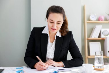 Ofisteki bir masaüstünde belge imzalayan bir yöneticinin ön görünüm portresi